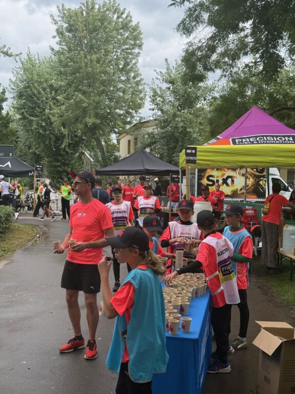 Freiwillige Helferinnen und Helfer reichen Getränke an der Verpflegungsstation beim IRONMAN 70.3 Leipzig.